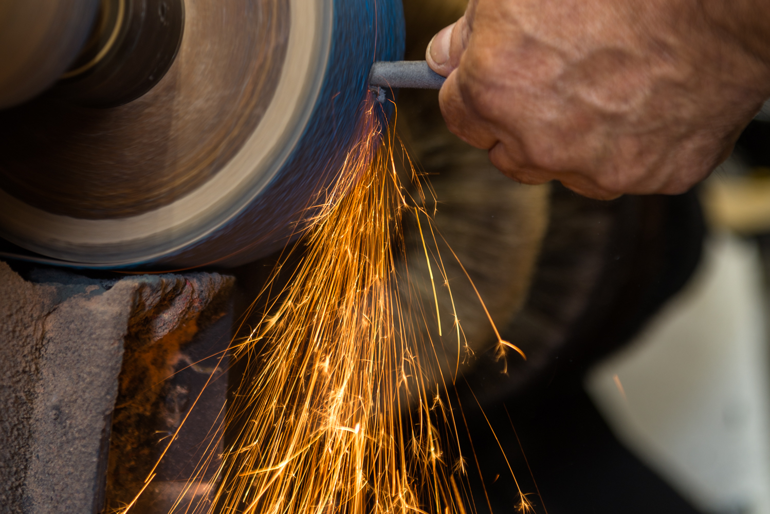 Cobbler grinding a heel at the workbench at Shoe Repair and Beyond